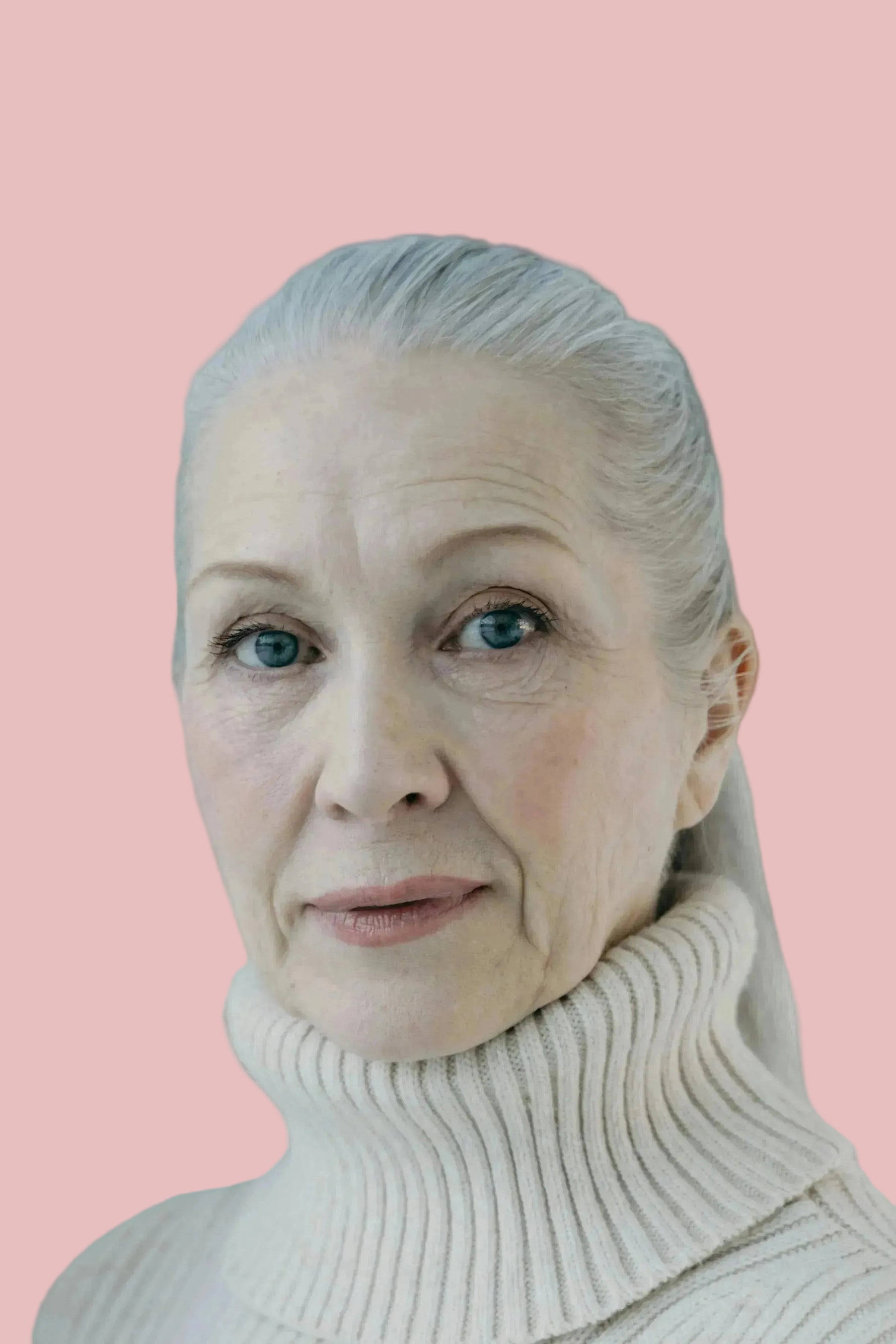 Woman wearing a beige turtleneck sweater against a pink background
